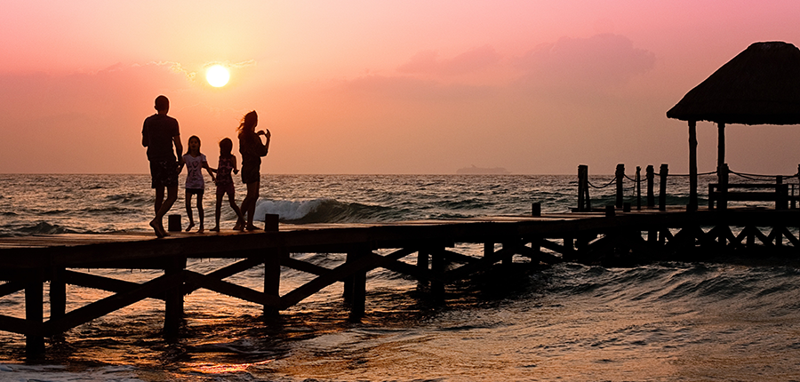 Family walking on pier that are working toward their goals with the help of their wealth manager